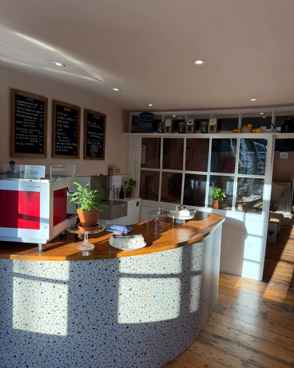 Inside fore. Topsham cafe with seating and counter