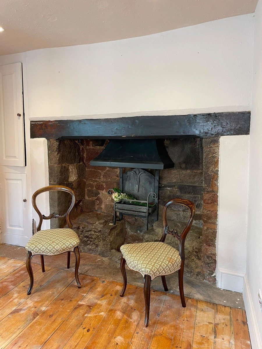 The restored original fireplace at fore.